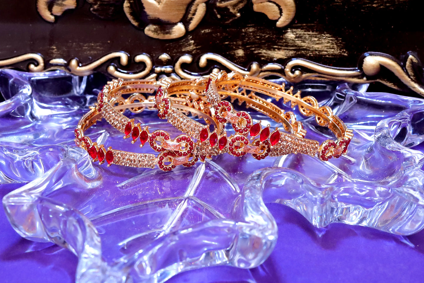 Rose gold headband with red gemstones on a decorative stand