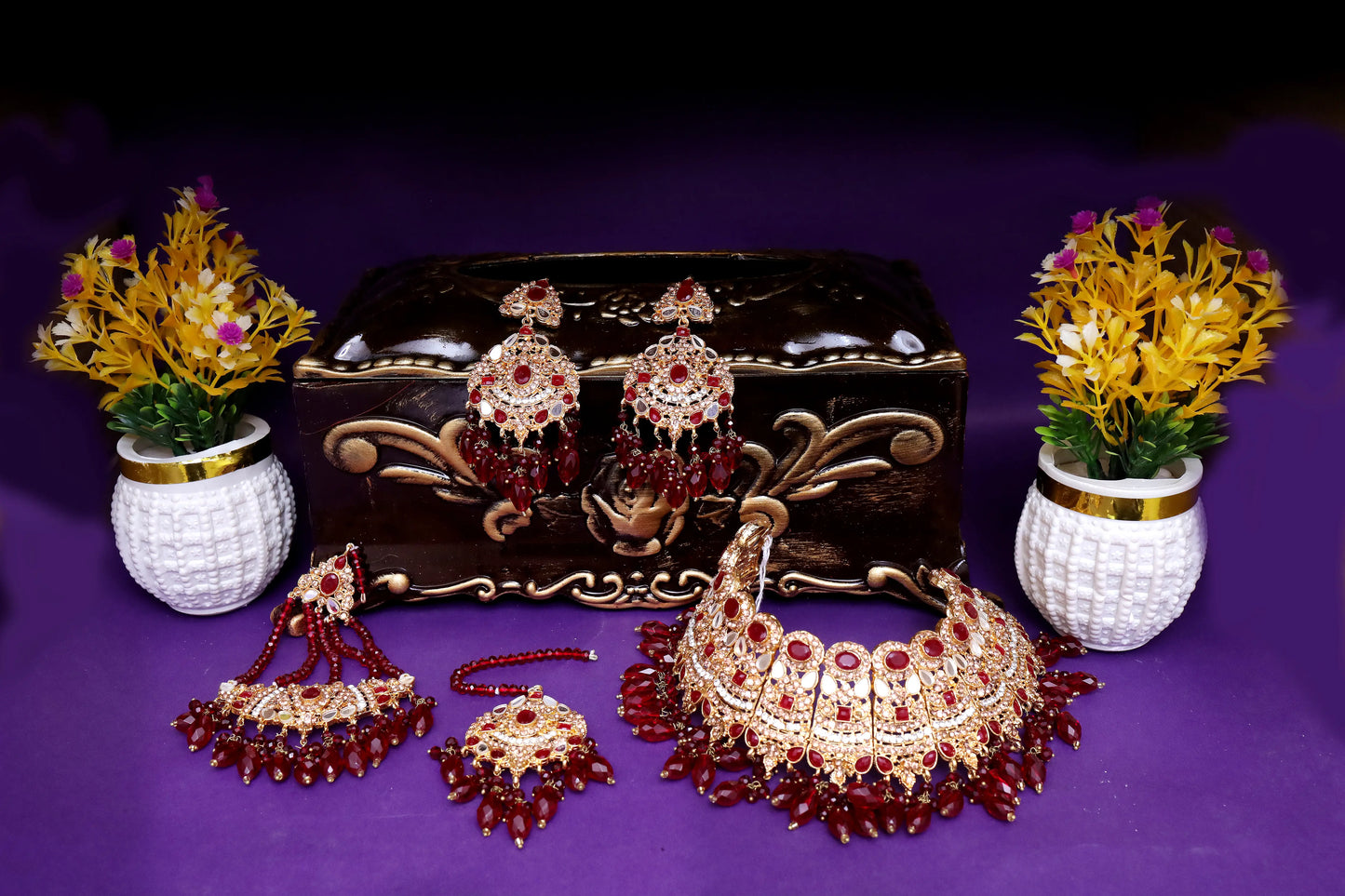Set of traditional jewelry including a necklace, earrings, and a decorative box on a purple background.