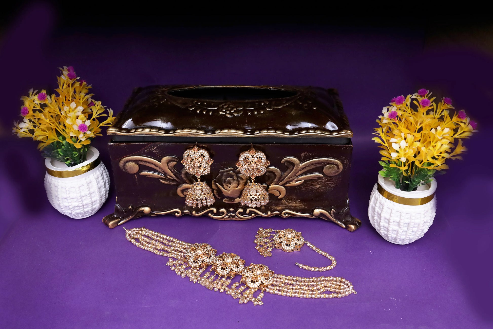 Decorative jewelry box with gold jewelry on a purple background
