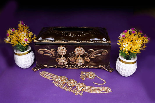 Decorative jewelry box with gold jewelry on a purple background