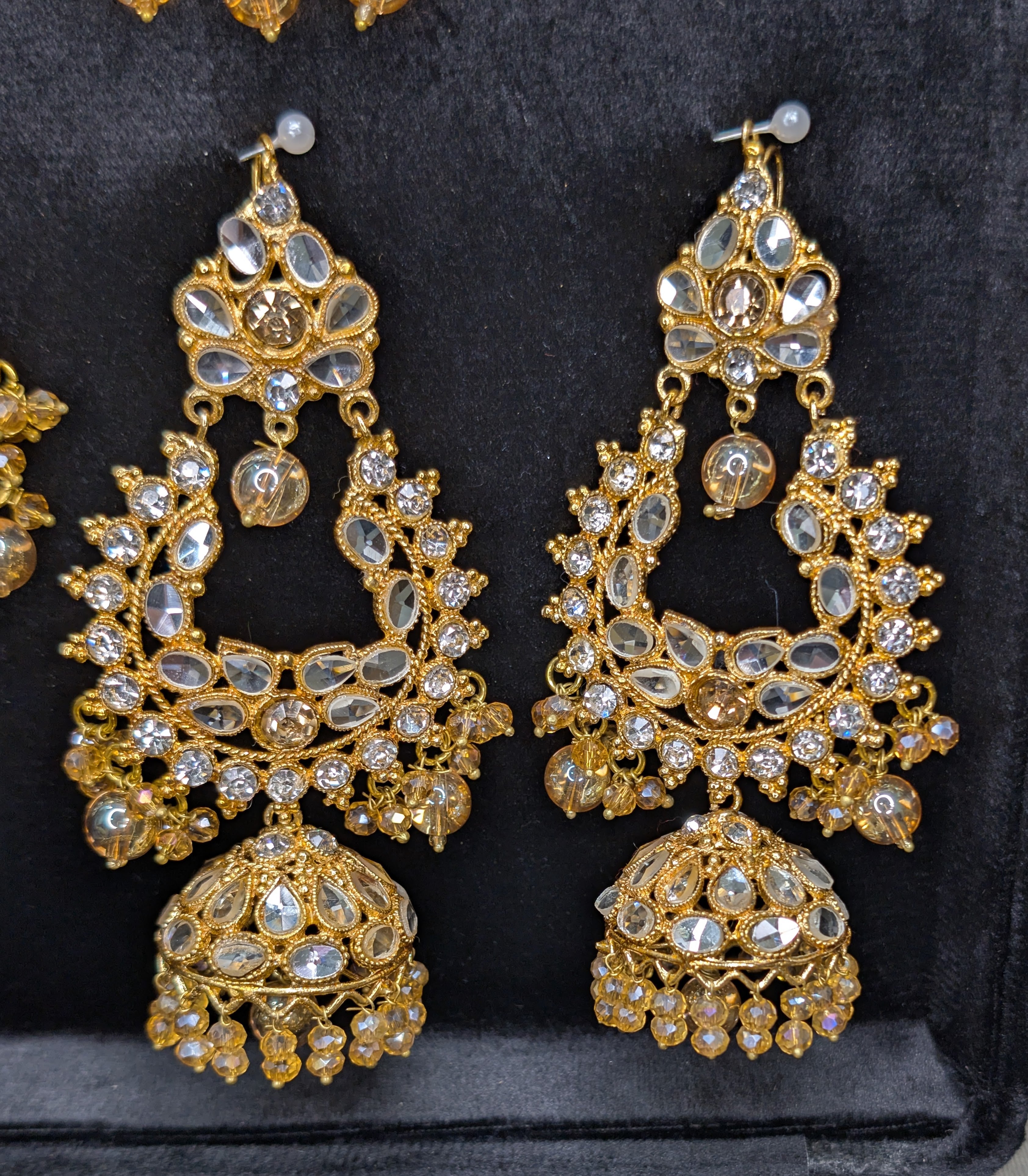 Gold and crystal earrings on a black background