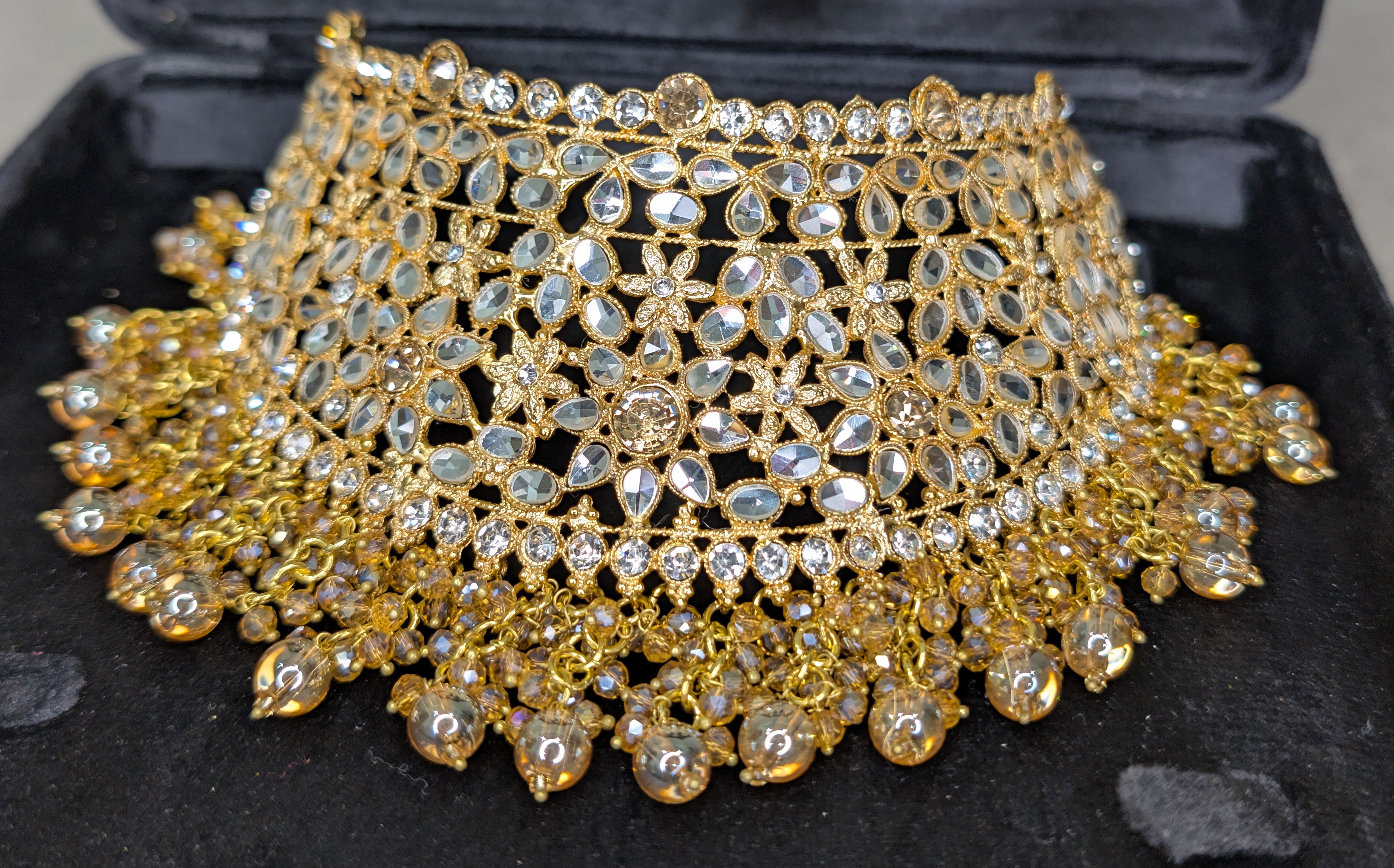 Gold and crystal necklace on a black display box