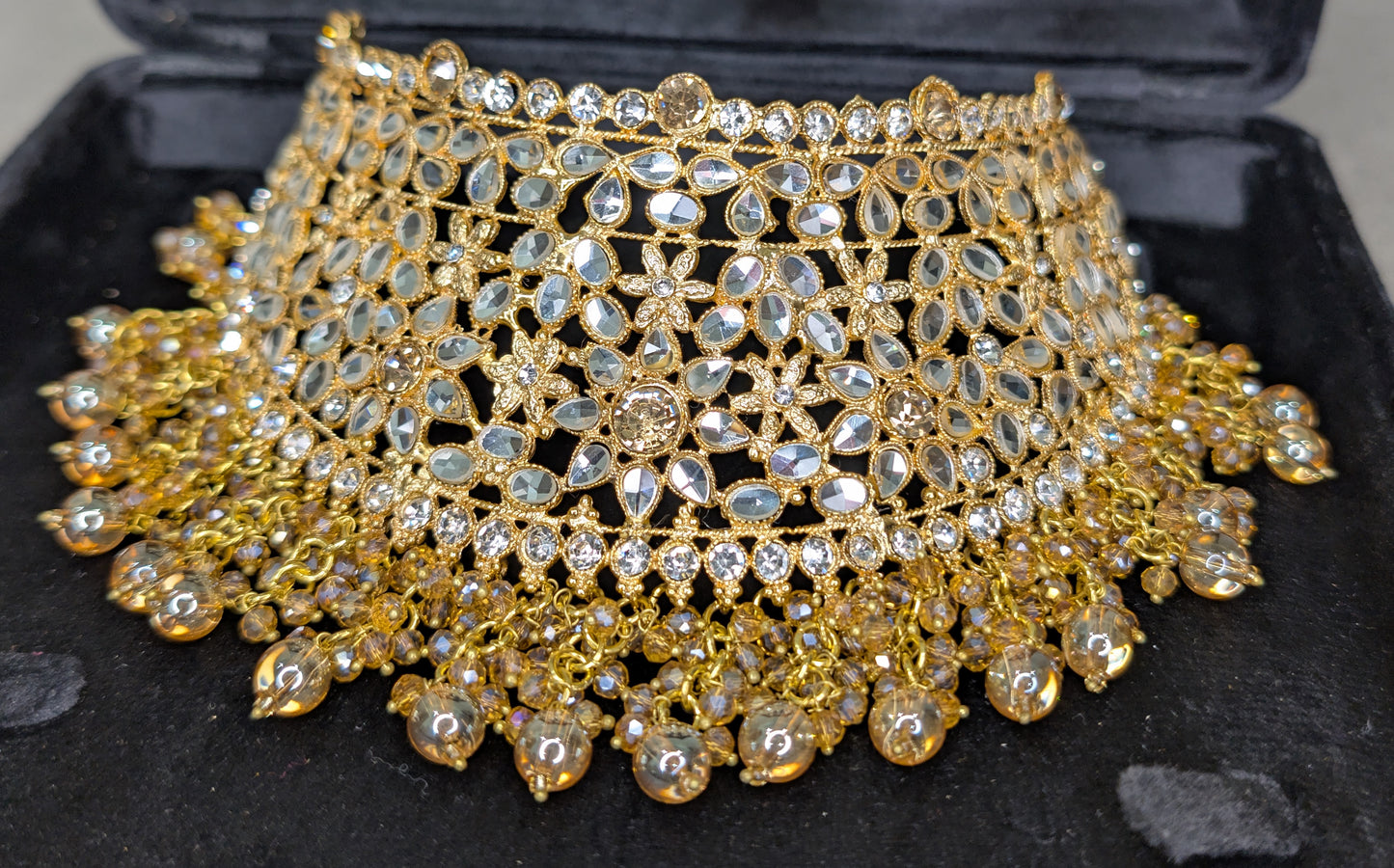 Gold and crystal necklace on a black display box