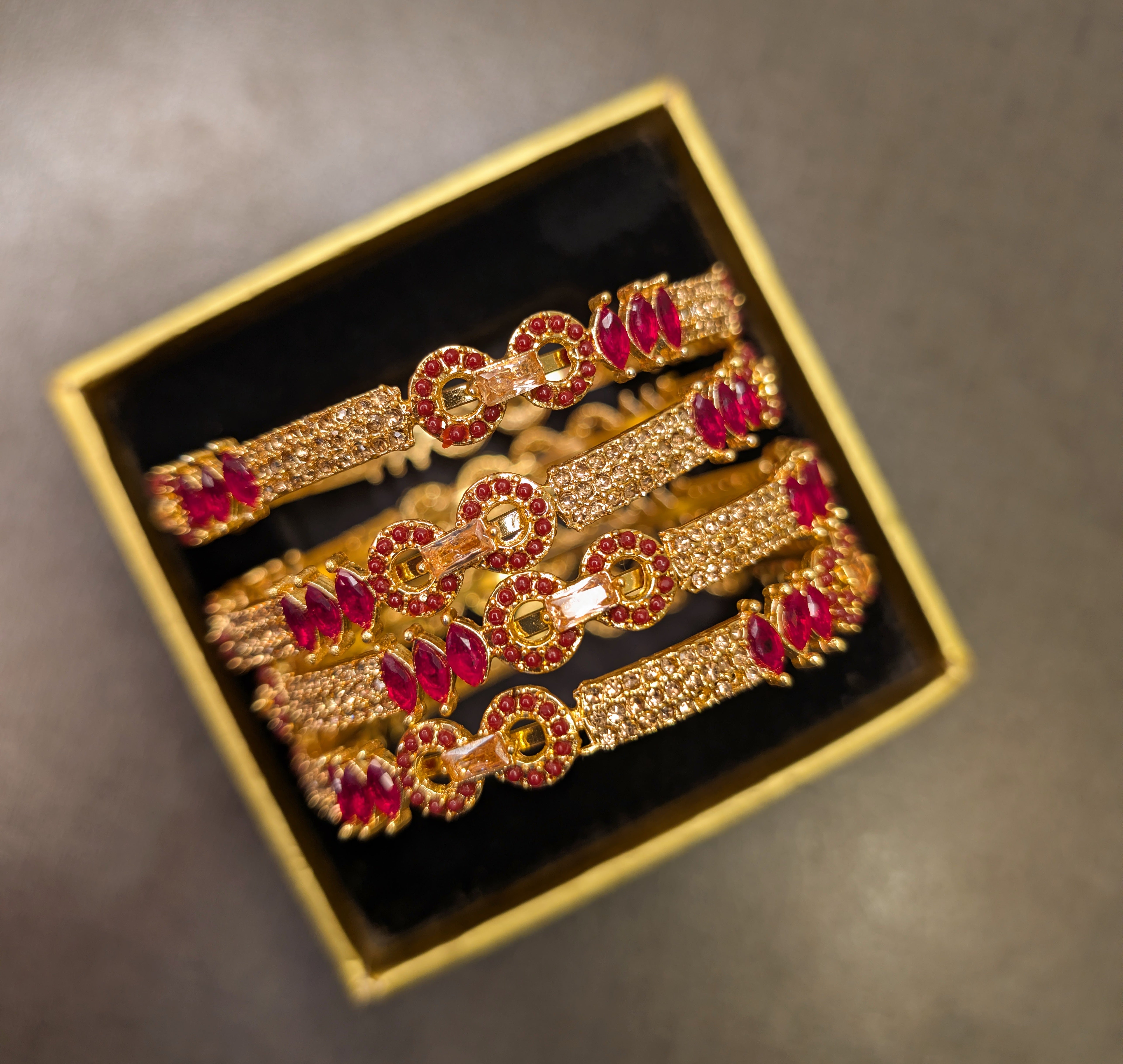 Gold and red gemstone hair clips in a box on a dark background