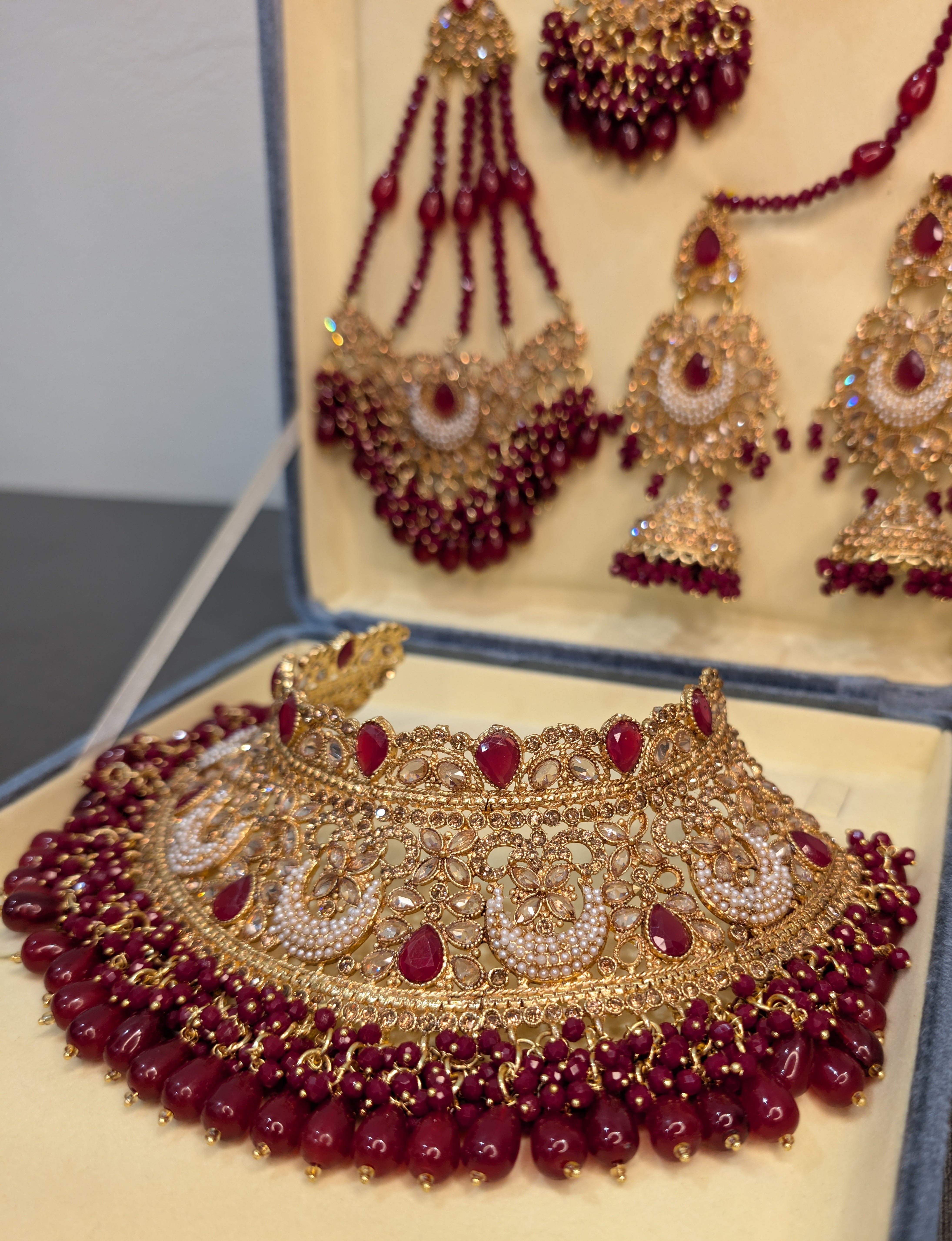 Gold and red jewelry set on a display box