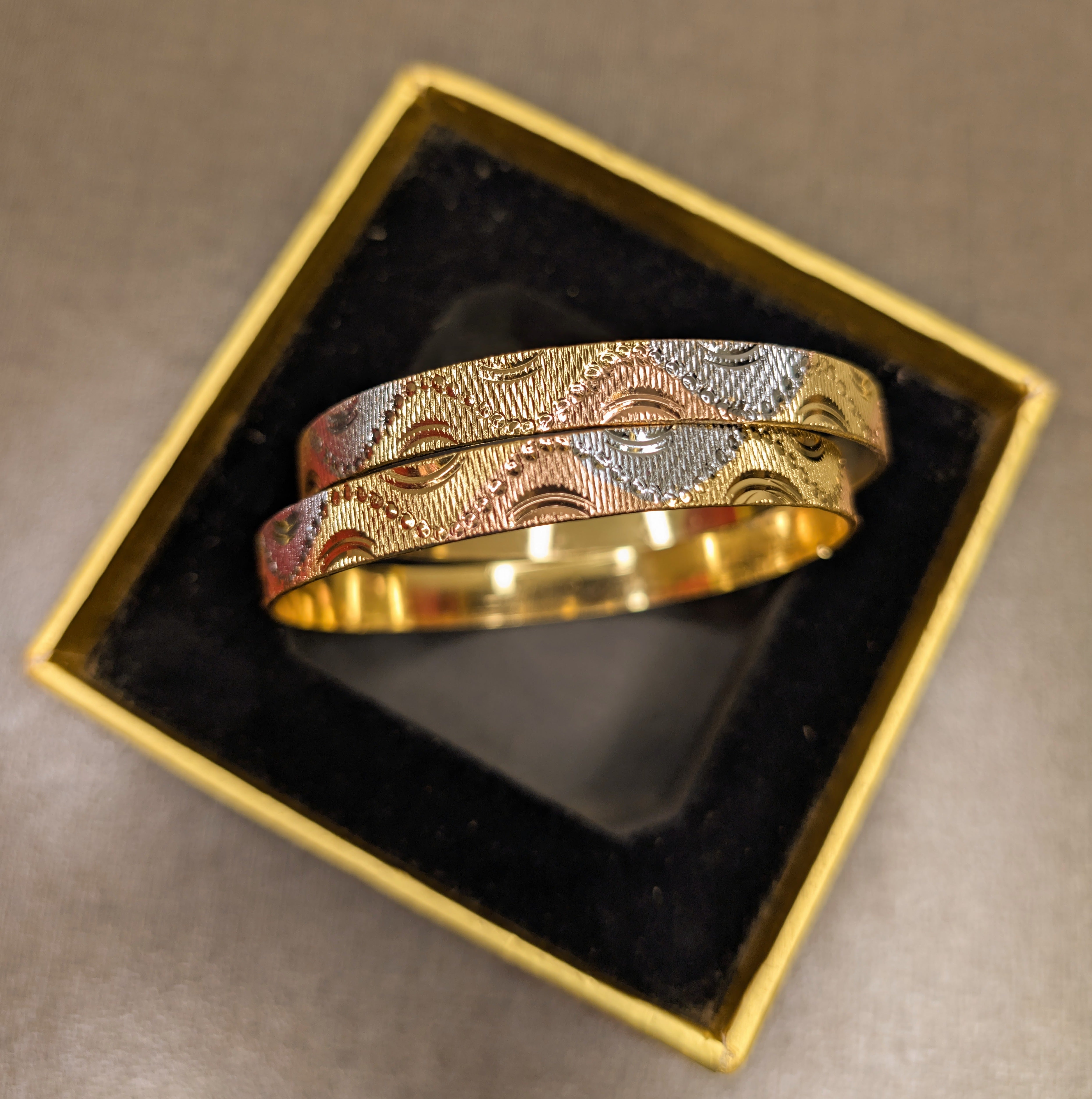 Gold and silver bracelet in a decorative box on a brown surface