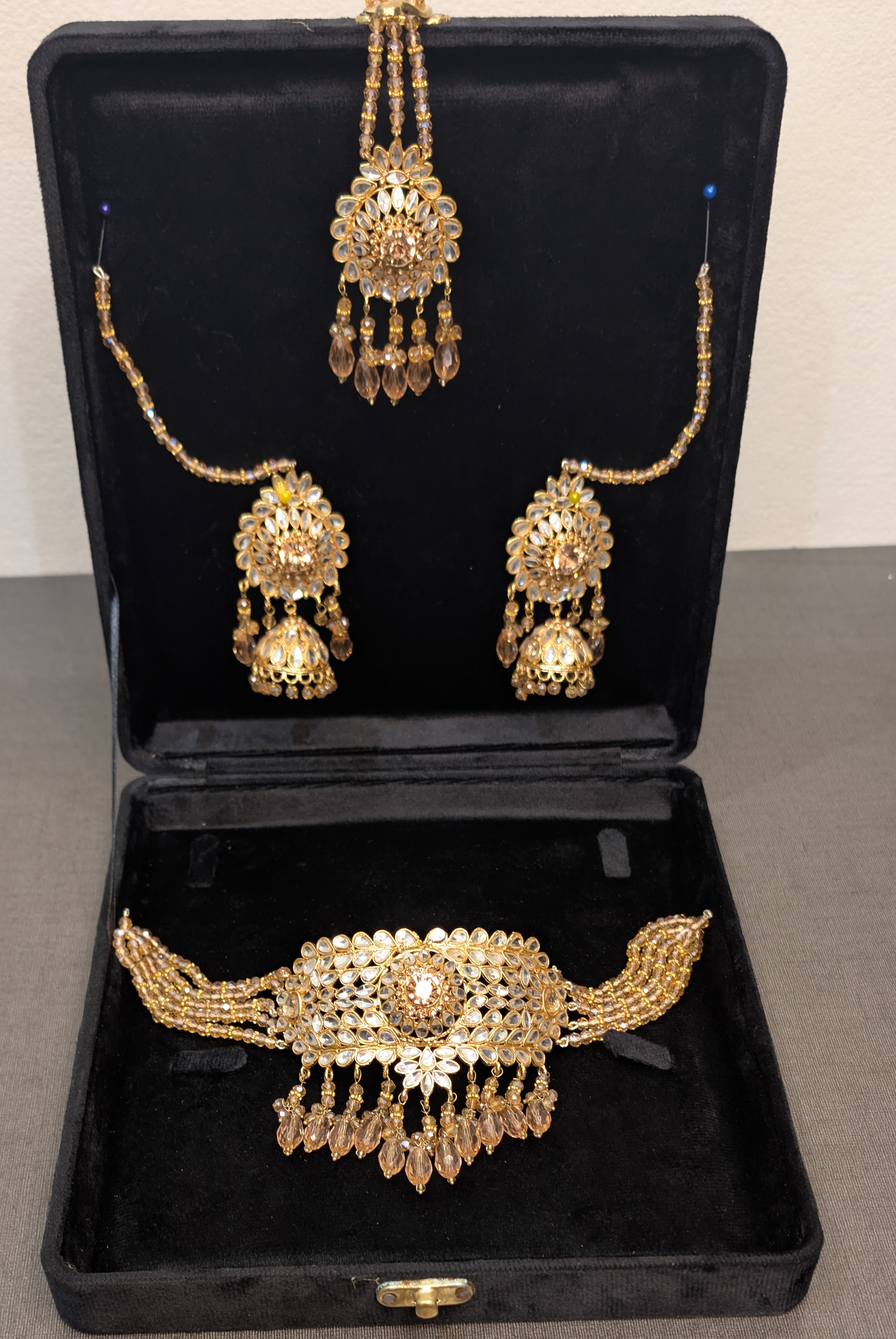 Gold jewelry set including necklace, earrings, and bracelet in a black display box.