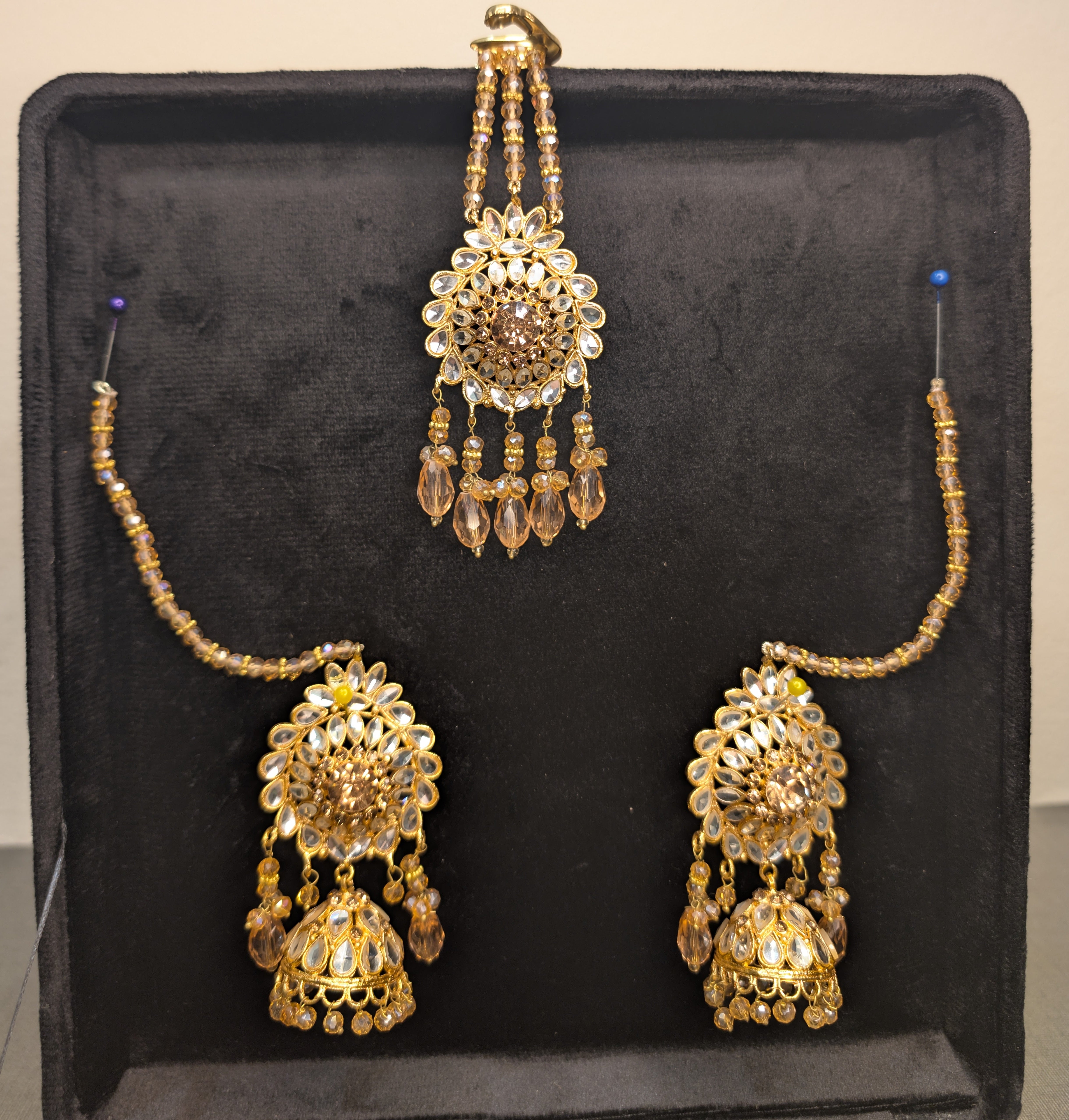 Gold necklace and earrings set on a black display box