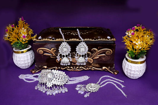 Jewelry set with earrings, necklace, and decorative box on a purple background