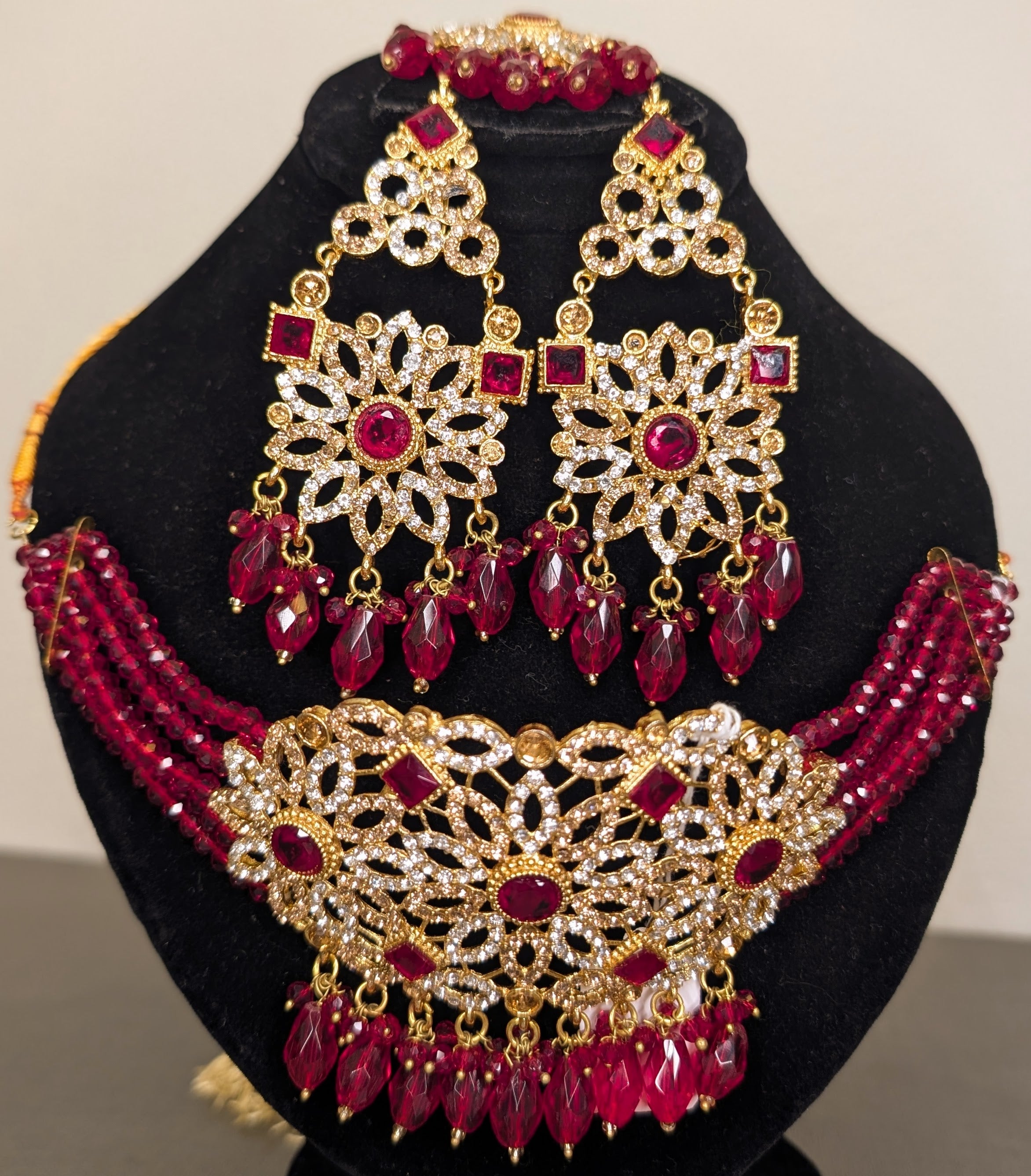 Jewelry set with necklace and earrings on a black stand