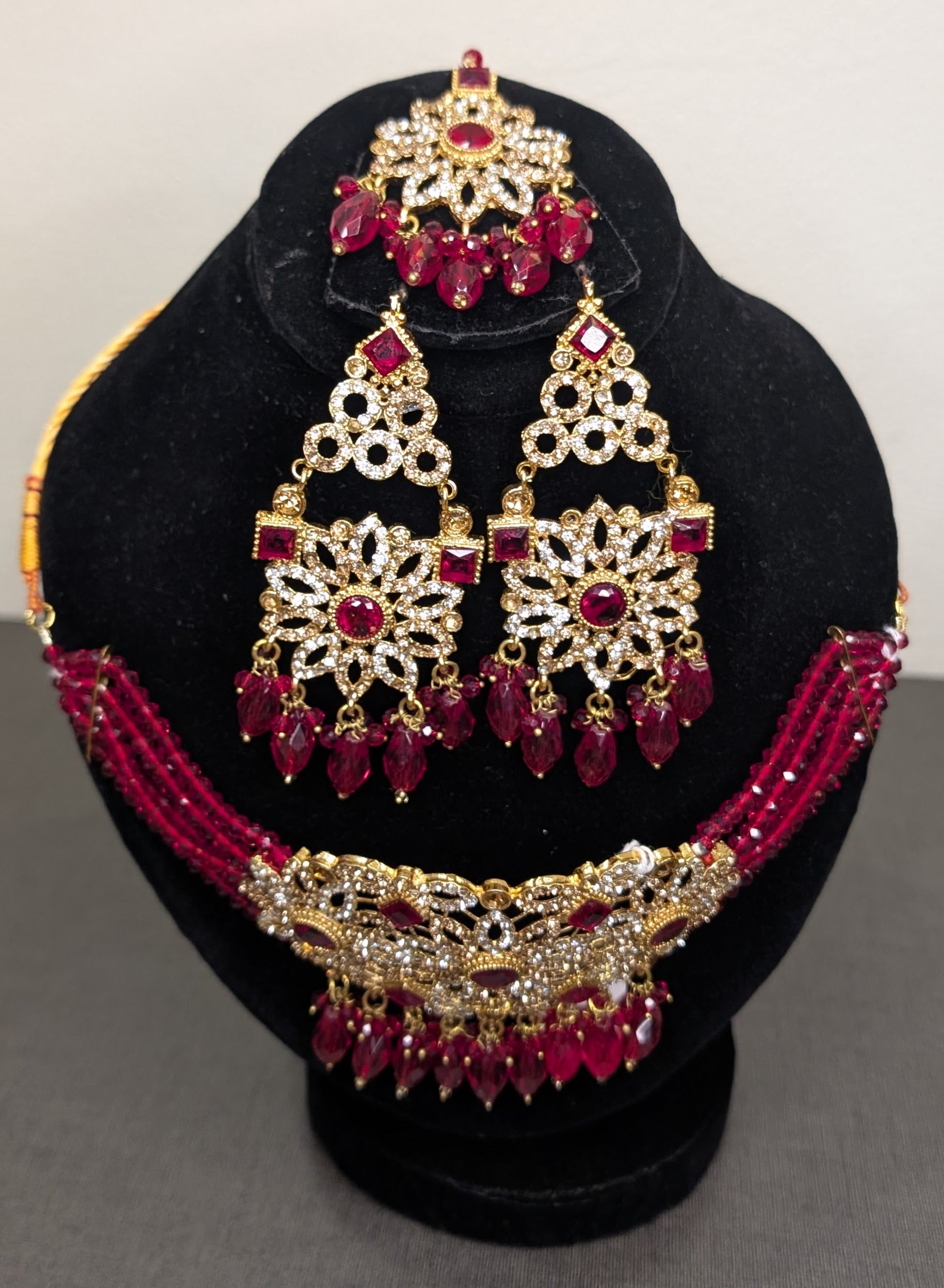 Jewelry set with necklace and earrings on a black stand