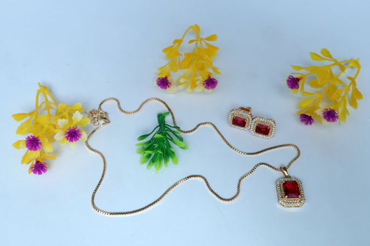 Jewelry set with necklace and earrings on a light blue background with artificial flowers.