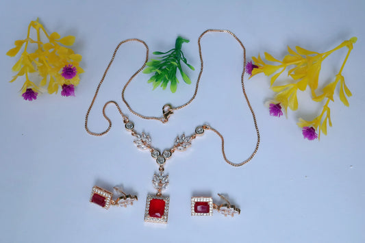 Jewelry set with necklace and earrings on a light blue background with artificial plants.