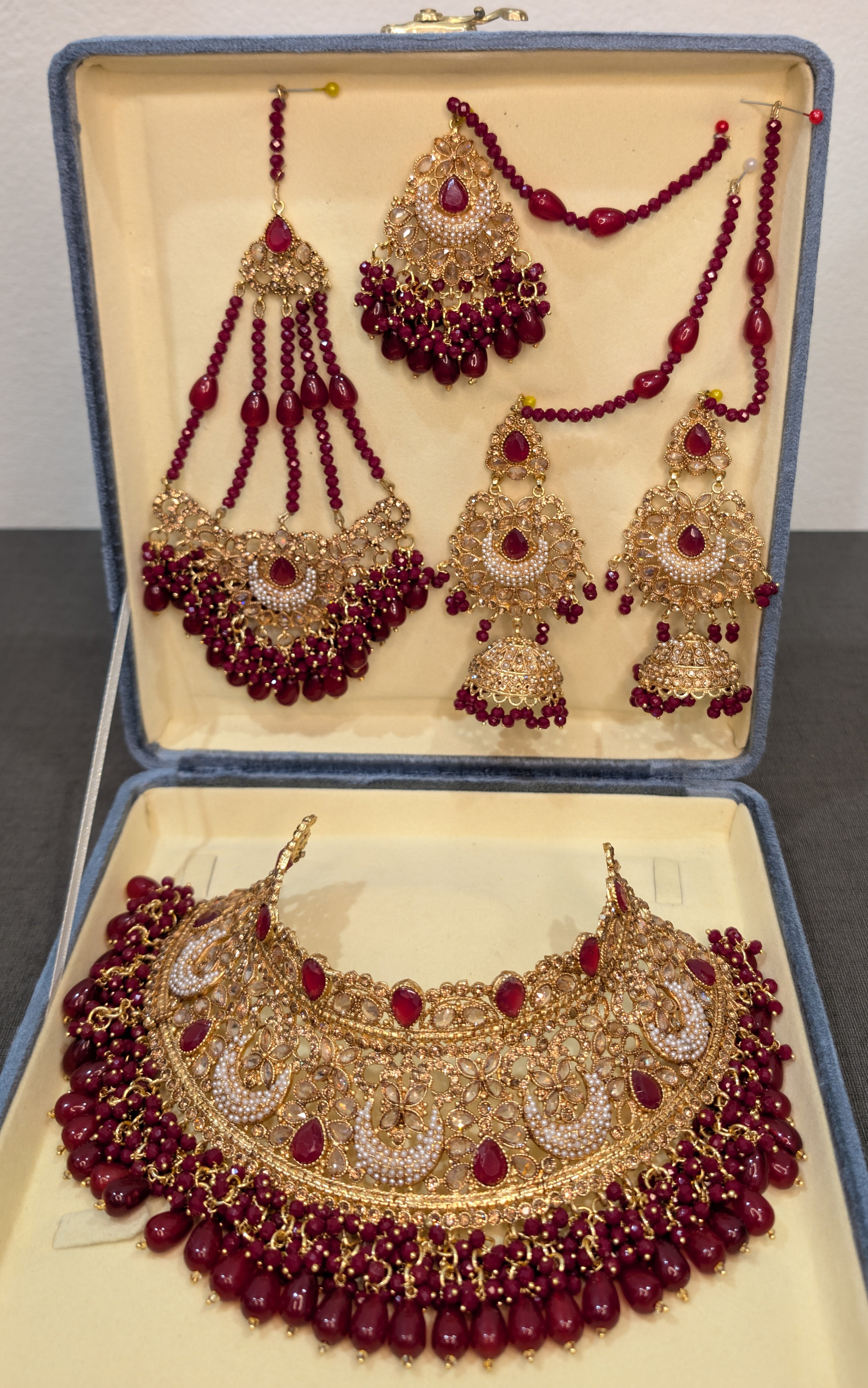 Jewelry set with necklace, earrings, and tikka in an open jewelry box.