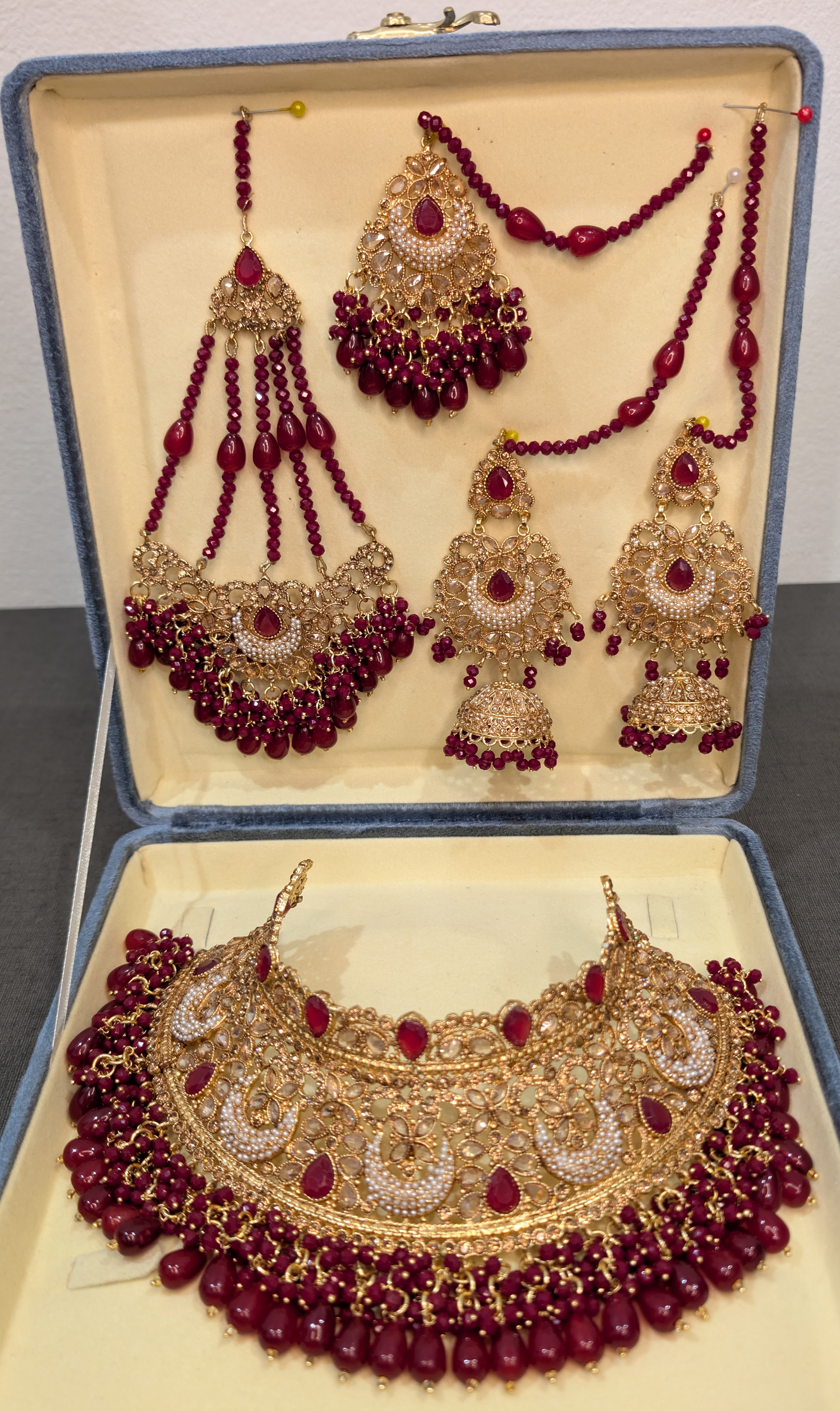 Jewelry set with red beads and gold accents in a box