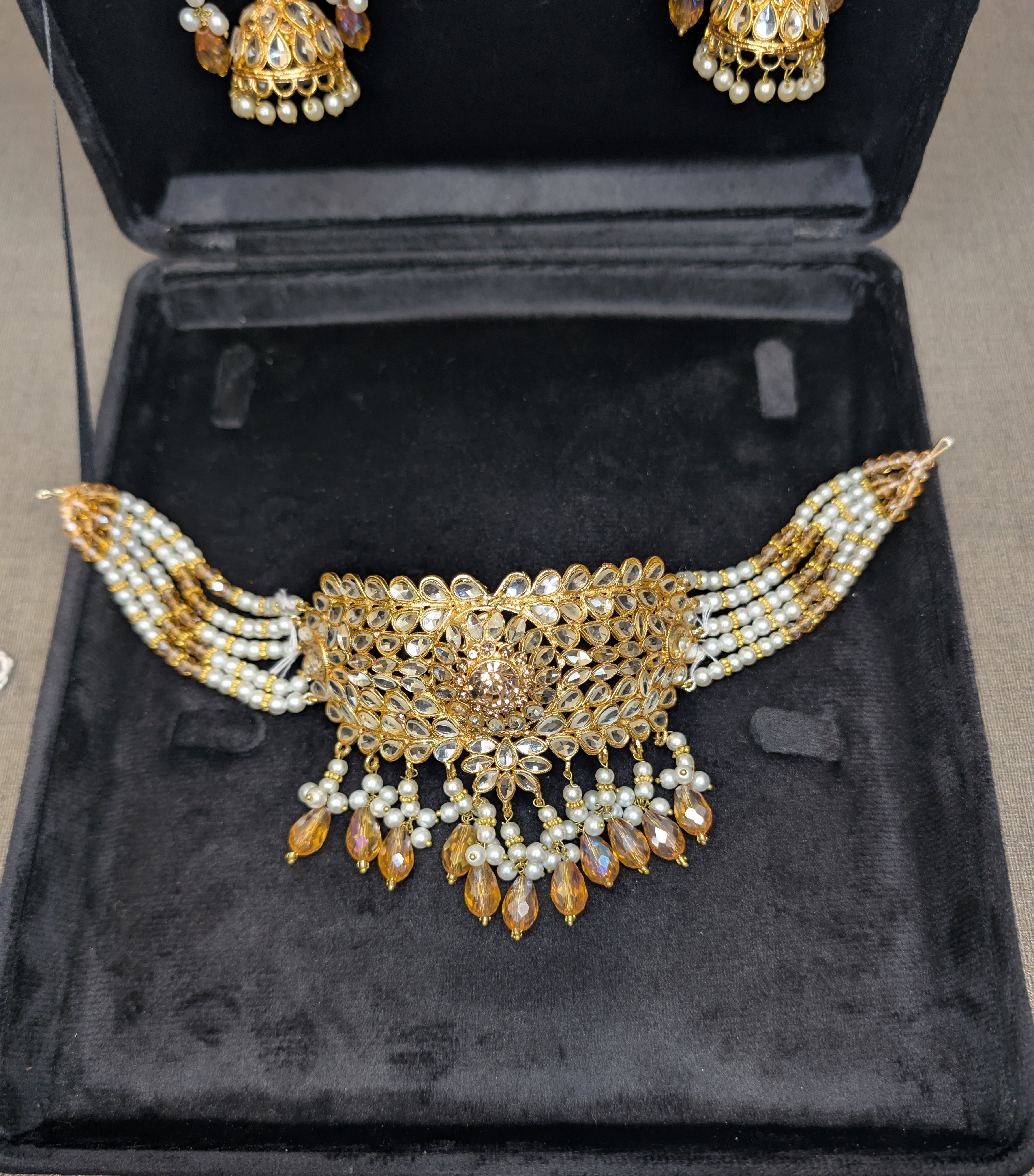 Ornate gold and pearl necklace in a black jewelry box
