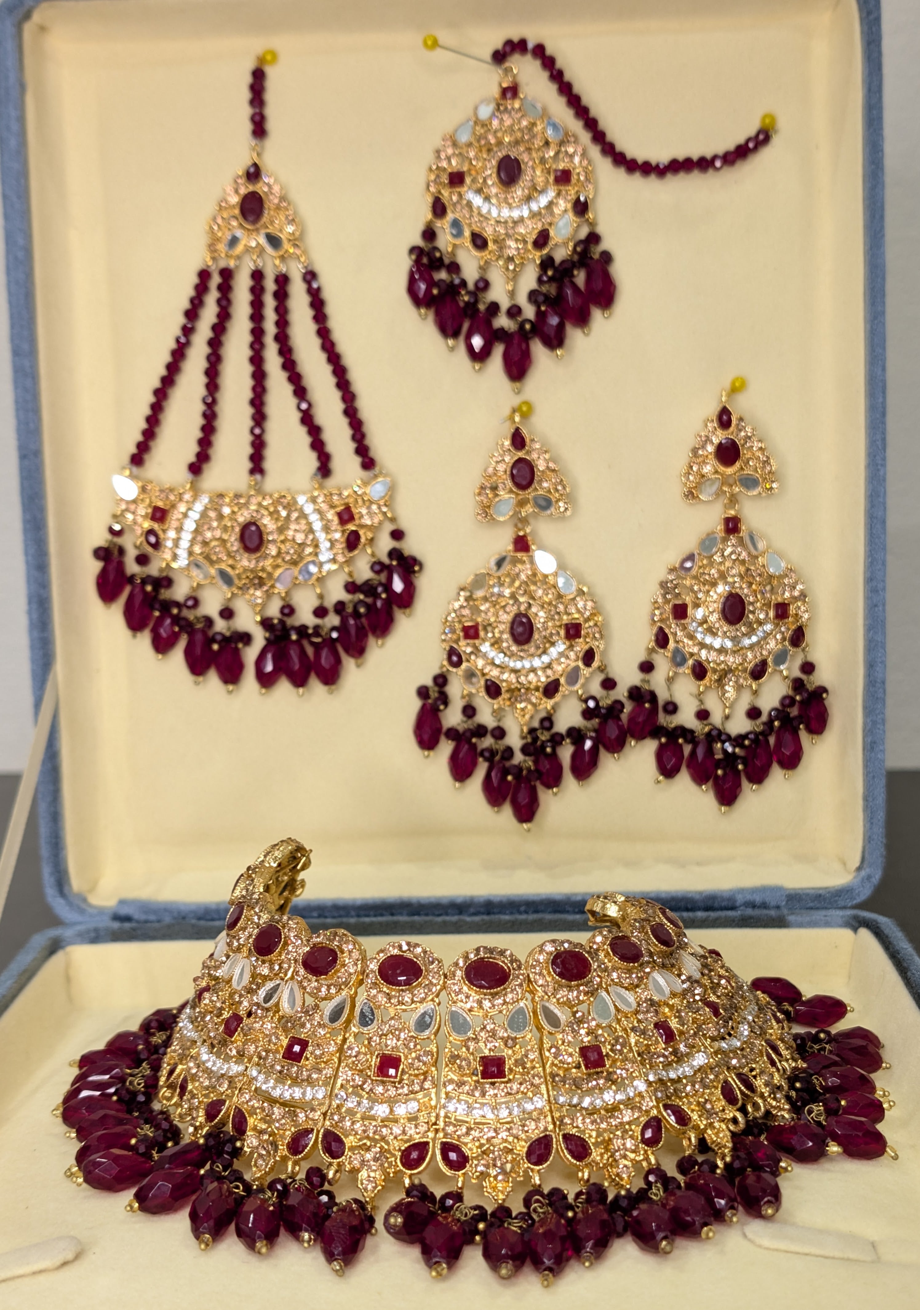 Ornate gold and red gemstone jewelry set in a box