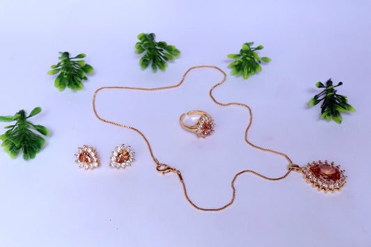 Pendent set with necklace, ring, and earrings on a white background with green leaves.