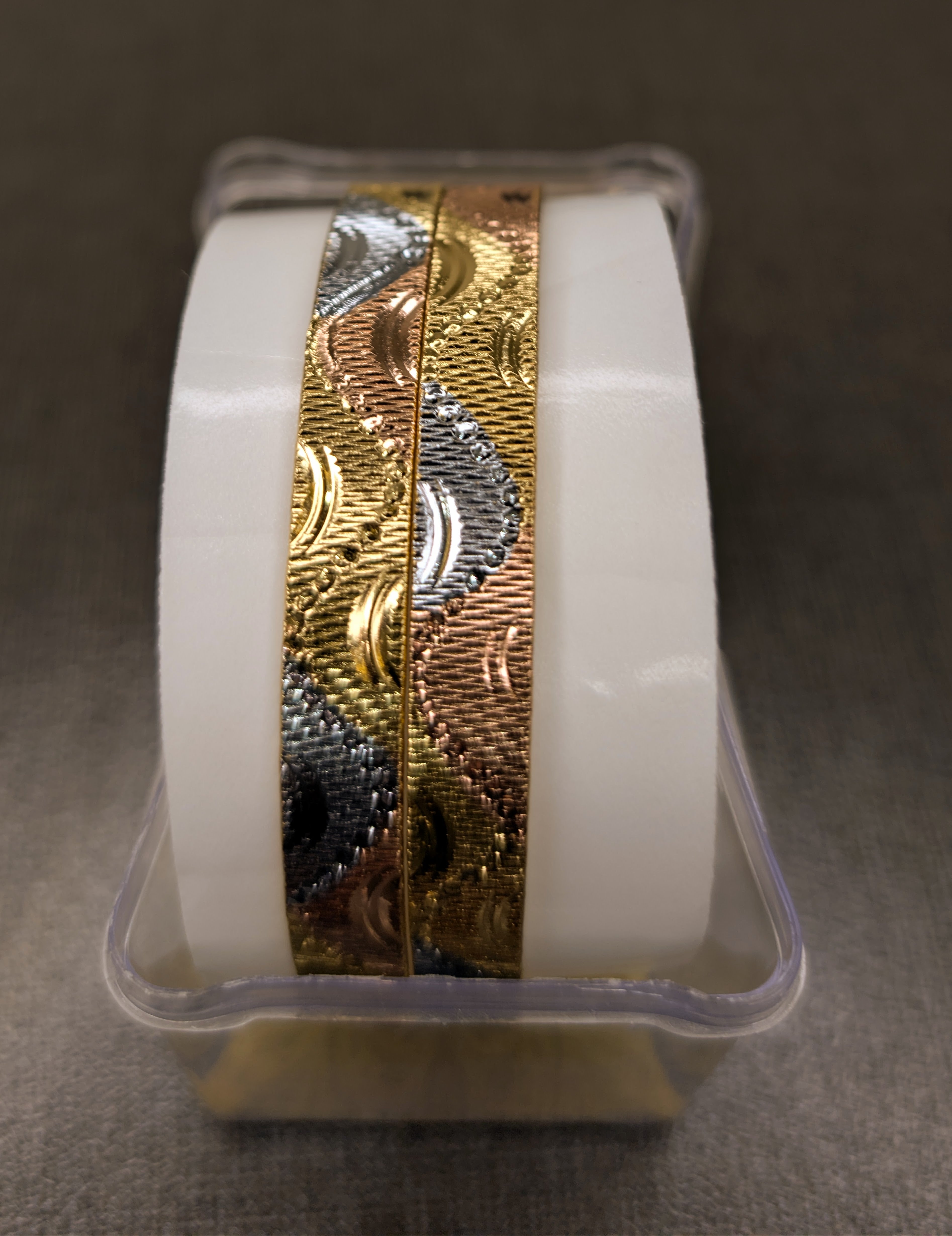 Roll of gold and silver metallic tape on a white background