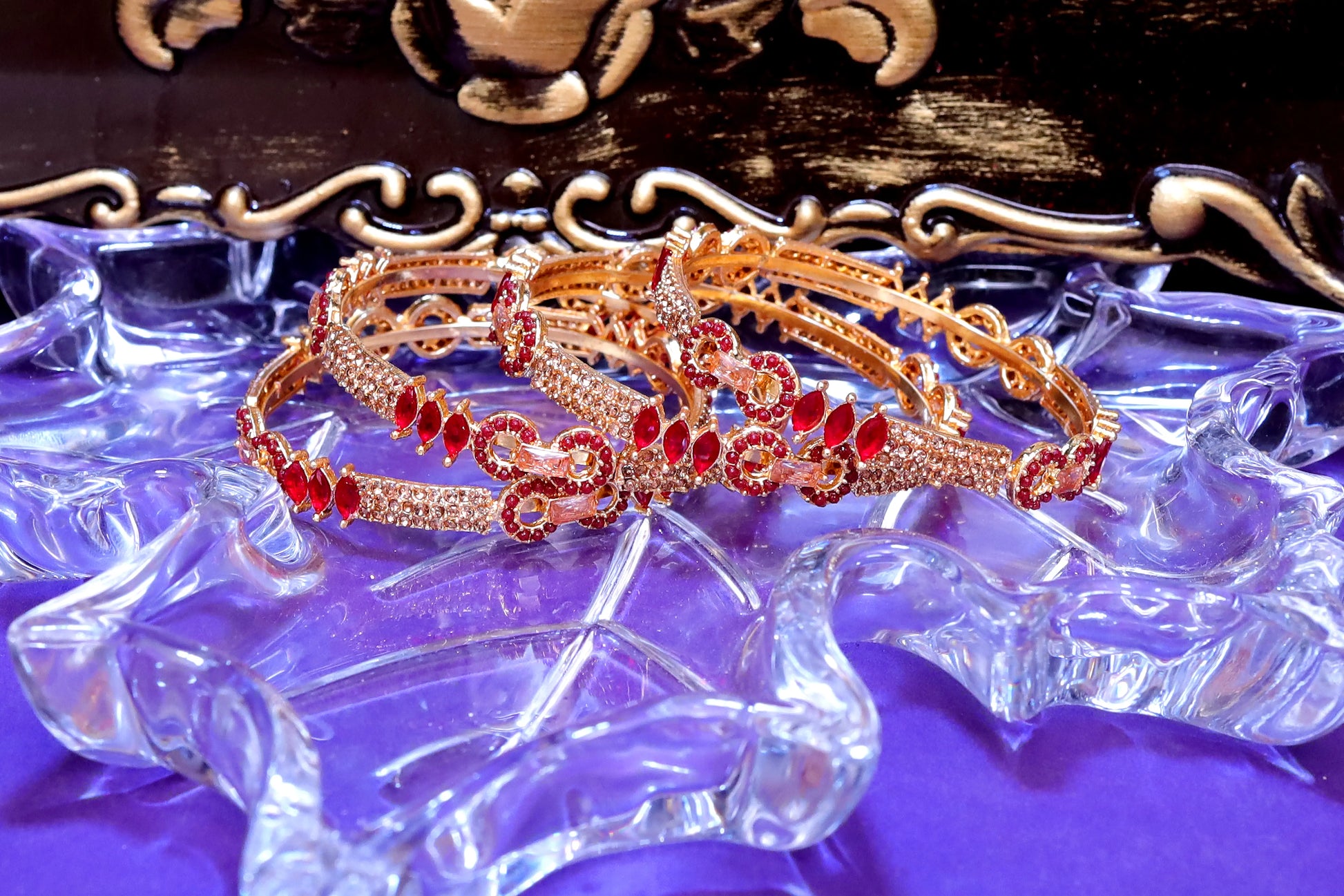 Rose gold headband with red gemstones on a decorative stand