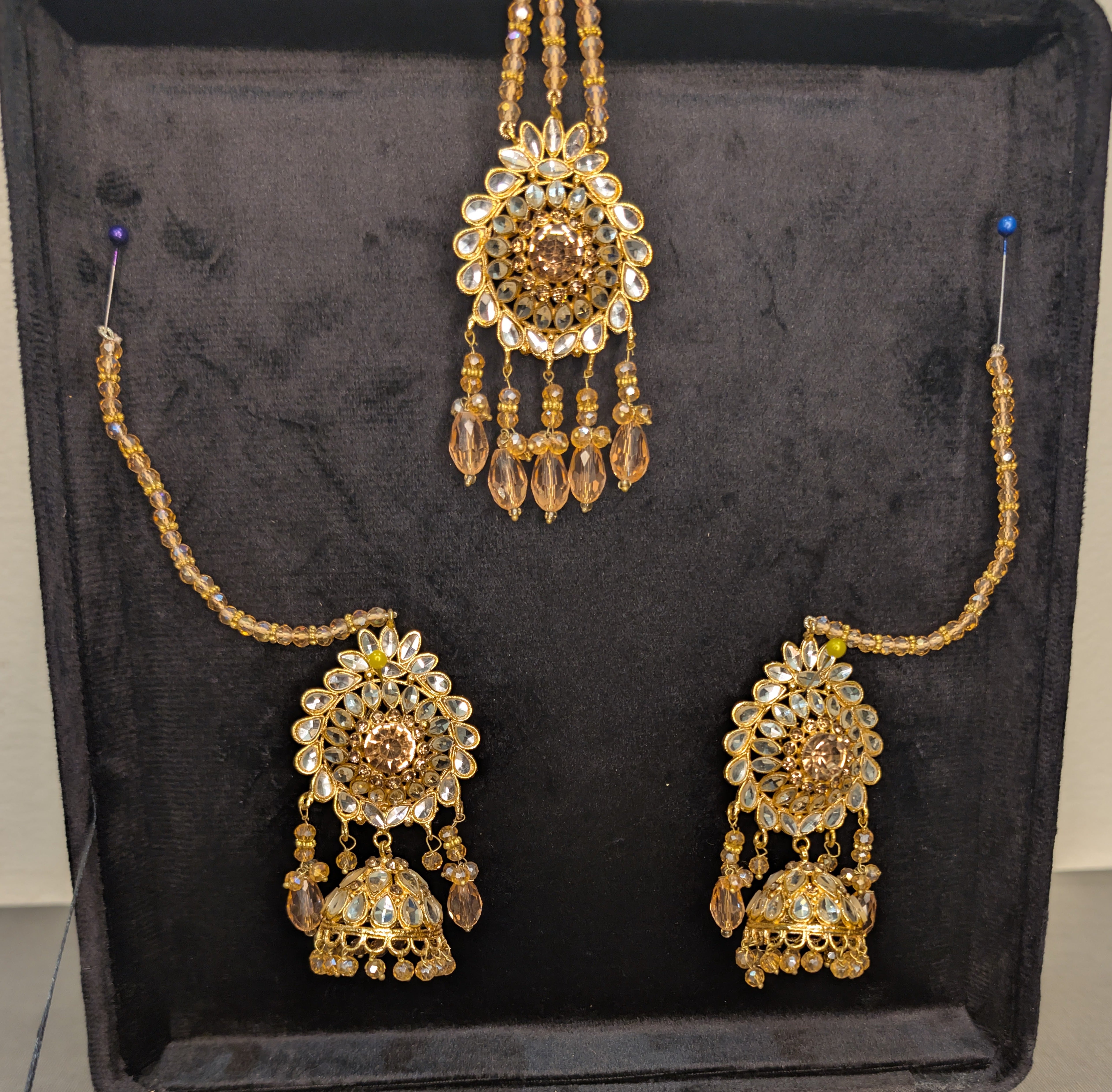 Set of gold necklaces with intricate designs on a black background