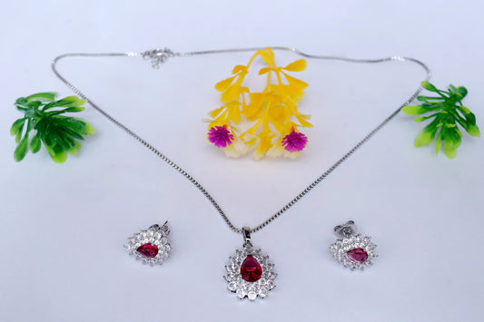 Silver jewelry set with red gemstones on a white background