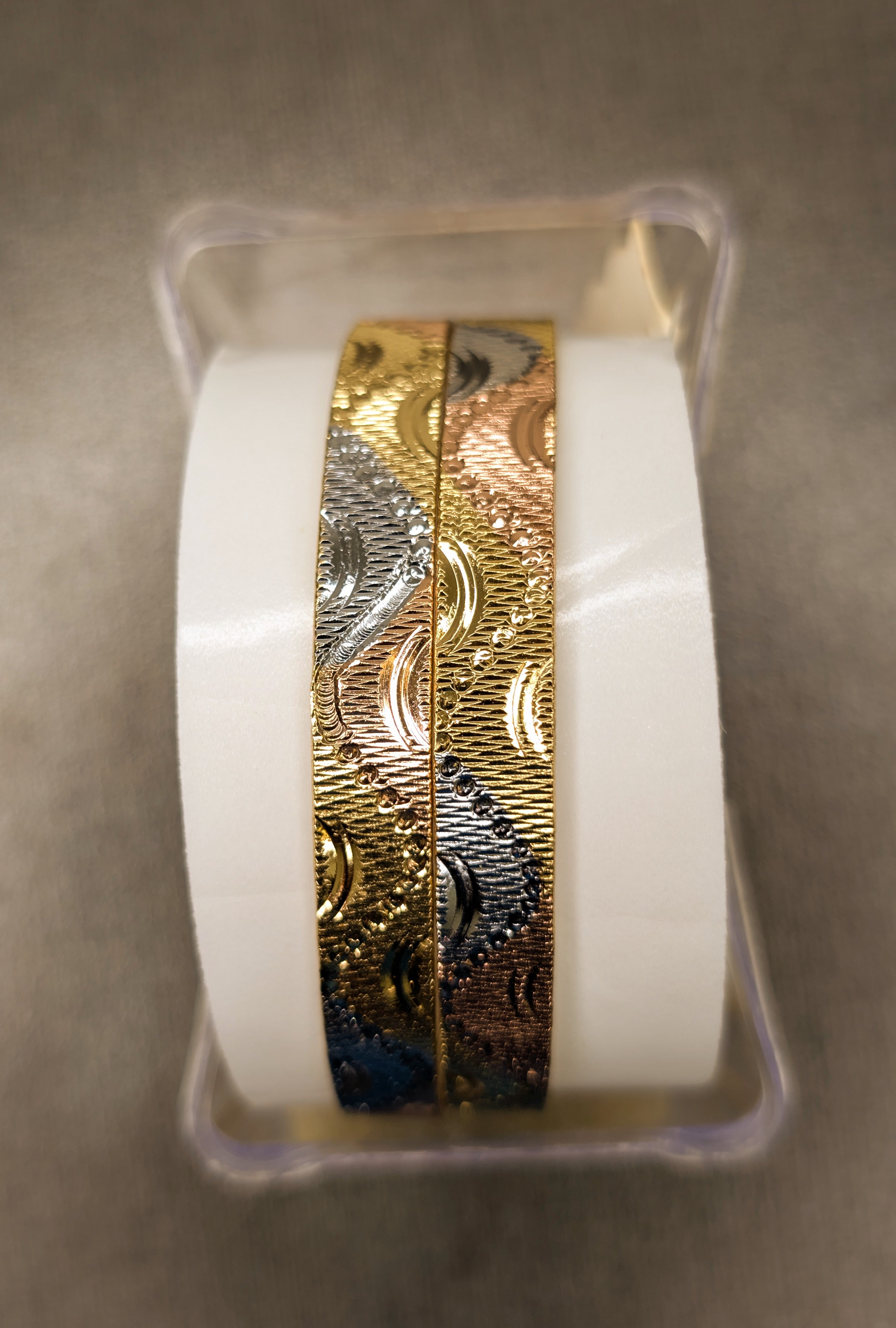 Two gold decorative tapes with intricate patterns on a gray background