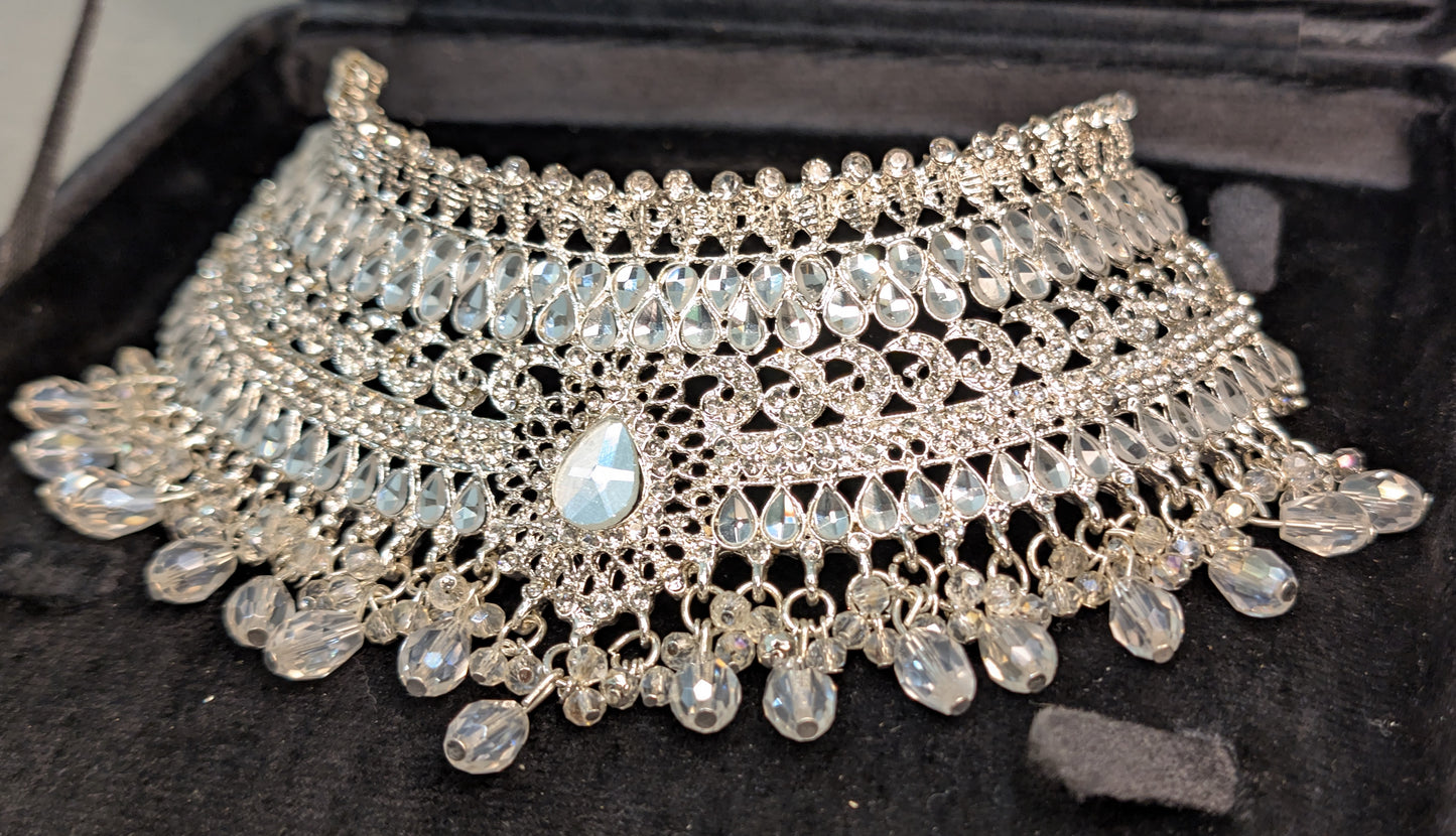 Silver necklace with beads on a black background