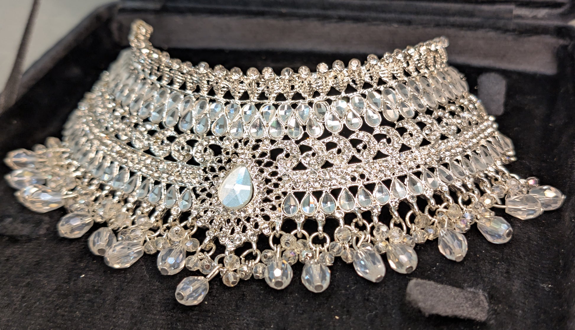 Silver necklace with beads on a black background